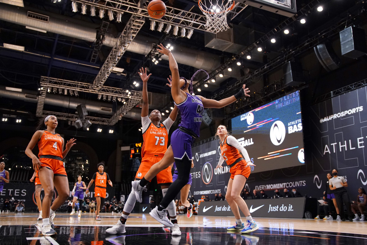 Team Carrington guard/forward DiJonai Carrington goes up for a layup with defenders around her